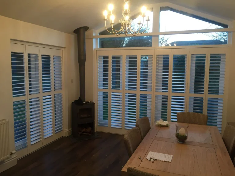 Track shutters in a spacious living room with large windows