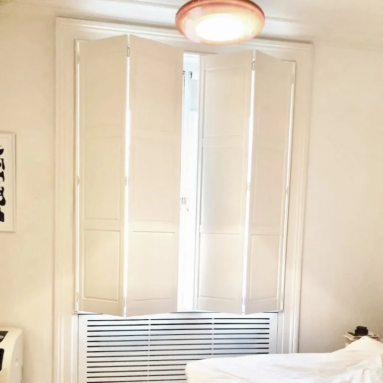 White solid shutters in a bright bedroom