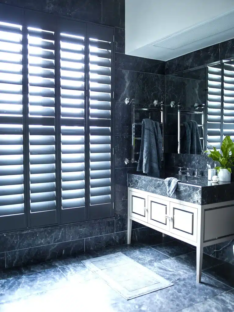 Dark grey full height shutters in a luxurious bathroom