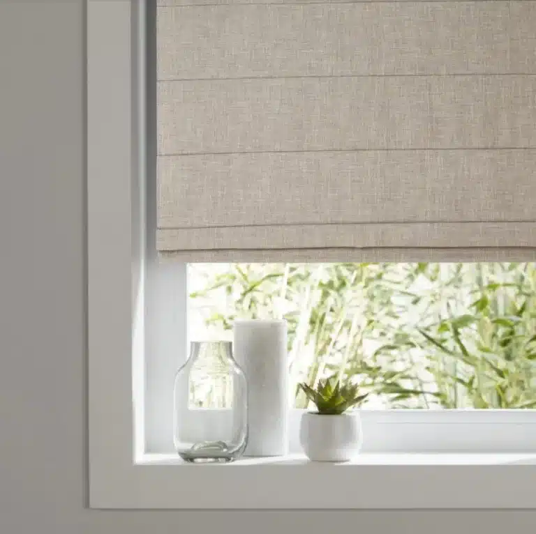 Beige Roman blinds in a cozy living room window