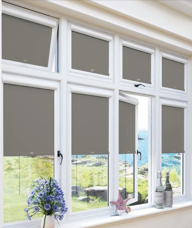 Grey perfect fit roller blinds in a conservatory