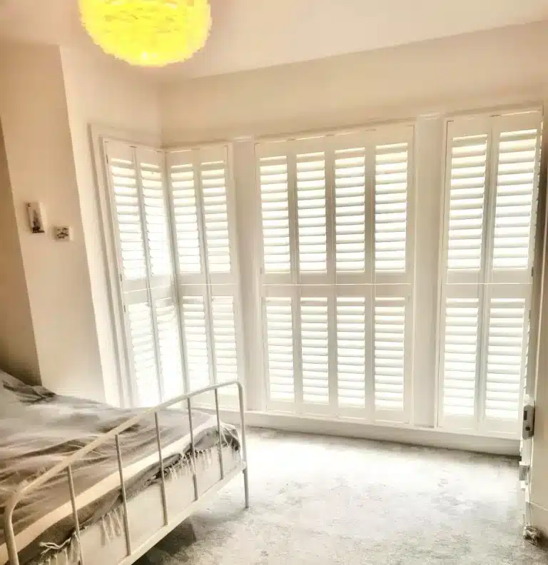 Premium wooden shutters in a contemporary grey kitchen featuring Smeg appliances, skylight, and industrial-style lighting