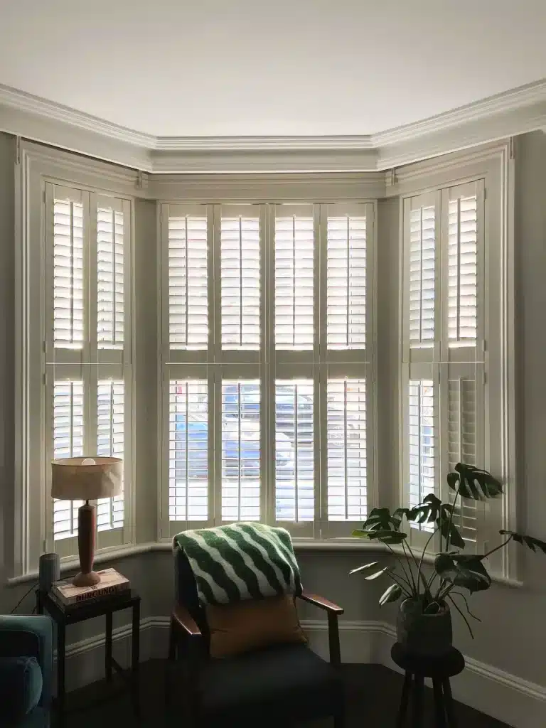 Elegant bedroom featuring tier-on-tier shutters in North London, designed by North London Shutters and Blinds