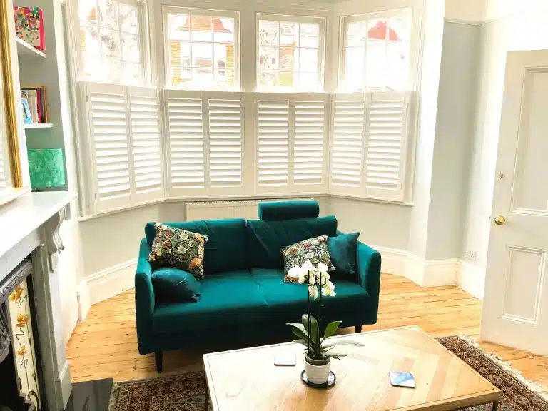 Bright living room featuring shutters on windows by North London Shutters and Blinds