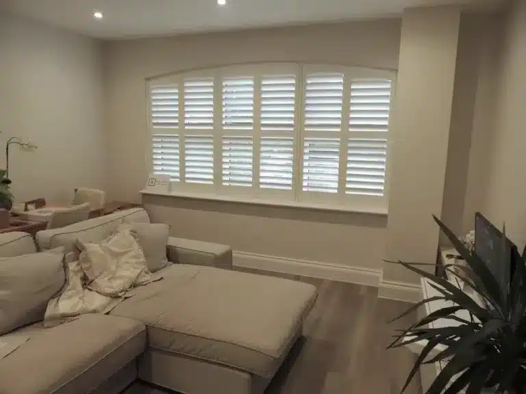 Custom-fitted solid window shutters providing privacy and light control in a contemporary North London living room