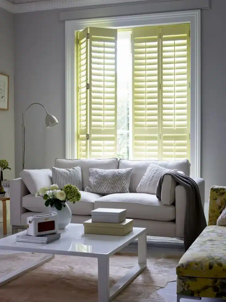Bright living room featuring custom interior wood shutters with adjustable louvers, allowing filtered natural light while maintaining privacy