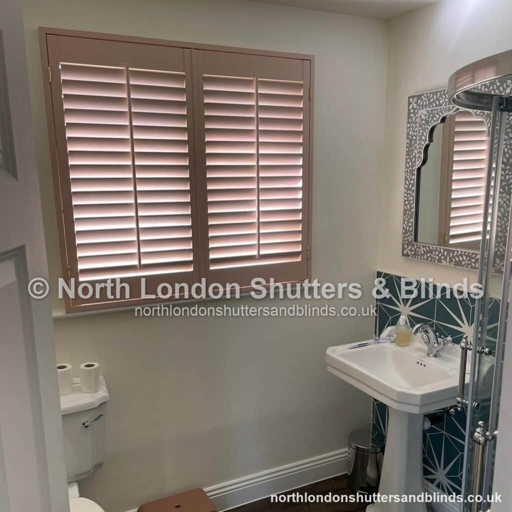 Pink full height plantation shutters in a bathroom by shutter fitters in Barnet, North London