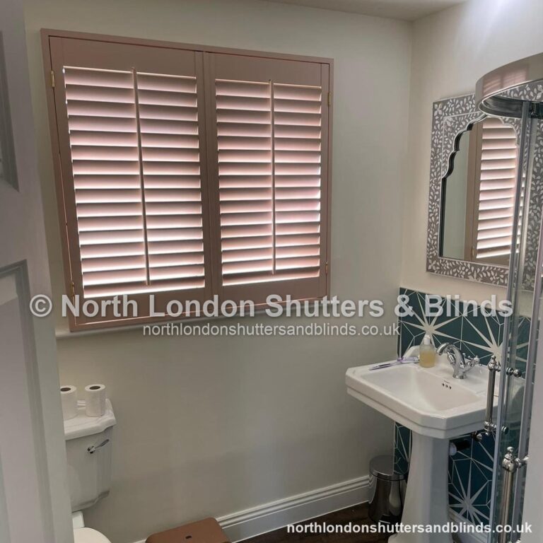 Pink full height plantation shutters in a bathroom by shutter fitters in Barnet, North London