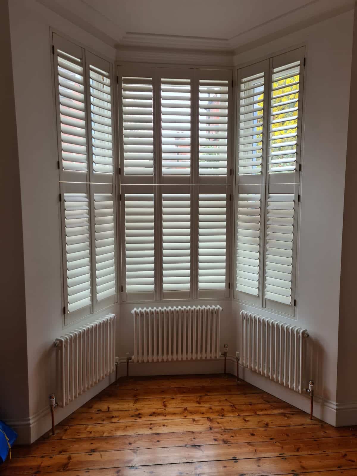 Wooden tier-on-tier shutters on a period bay window, North London