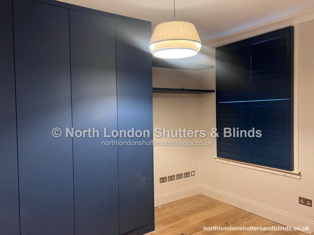 Blue full height plantation shutters in a bedroom by shutter fitters in Barnet, North London