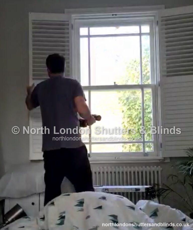 White full height plantation shutters on a sash window in a bedroom by shutter fitters in Barnet, North London