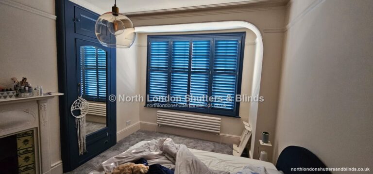 Navy blue full height plantation shutters in a bedroom by shutter fitters in Barnet, North London
