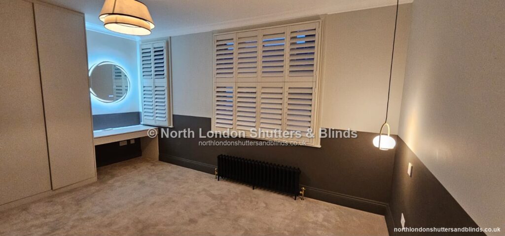 White full height plantation shutters in a dressing room, with the louvres closed by shutter fitters in Barnet, North London