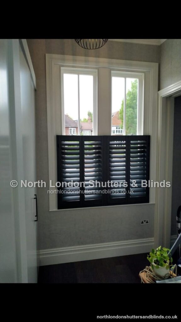 Black café style plantation shutters in a hallway by shutter fitters in Barnet, North London