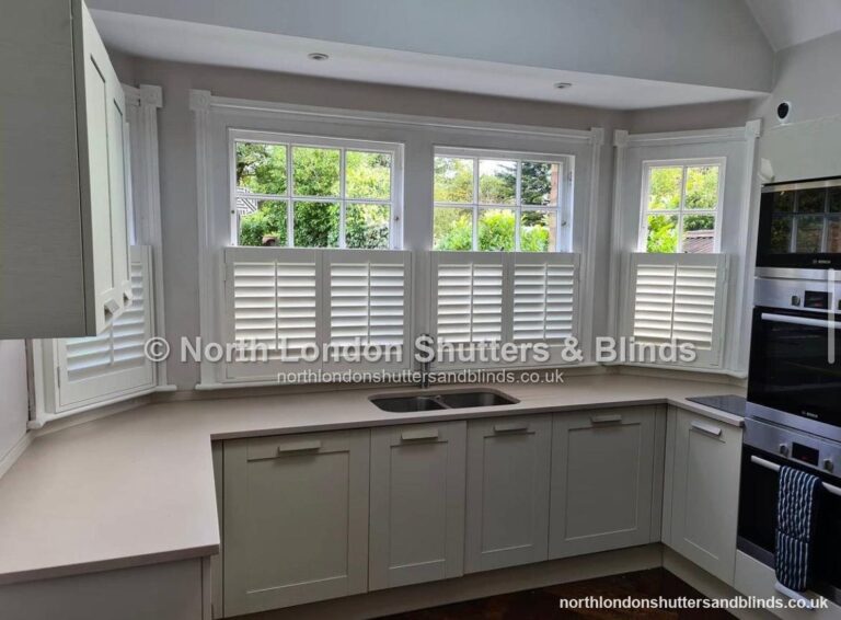 White café style plantation shutters on a bay window in a kitchen by shutter fitters in Barnet, North London