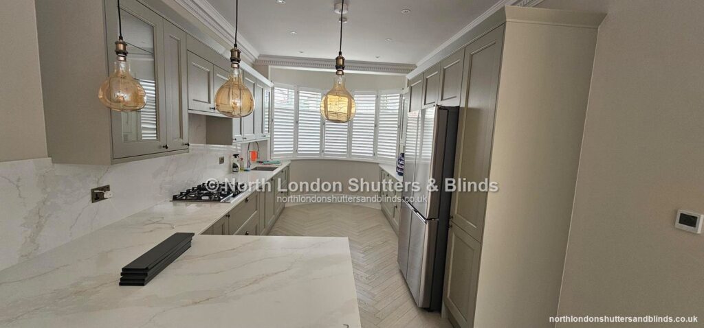 White full height plantation shutters on a wide window in a kitchen by shutter fitters in Barnet, North London