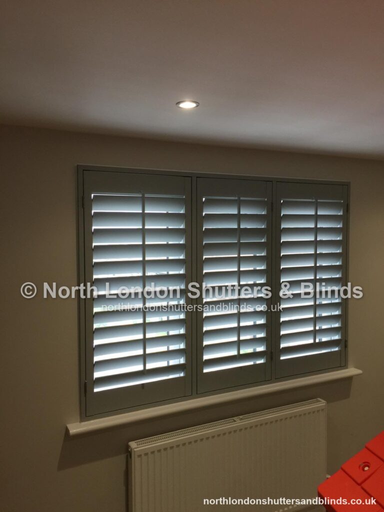 Dark grey full height plantation shutters in a living room by shutter fitters in Barnet, North London