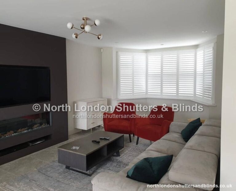 White full height plantation shutters on a bay window in a living room by shutter fitters in Barnet, North London