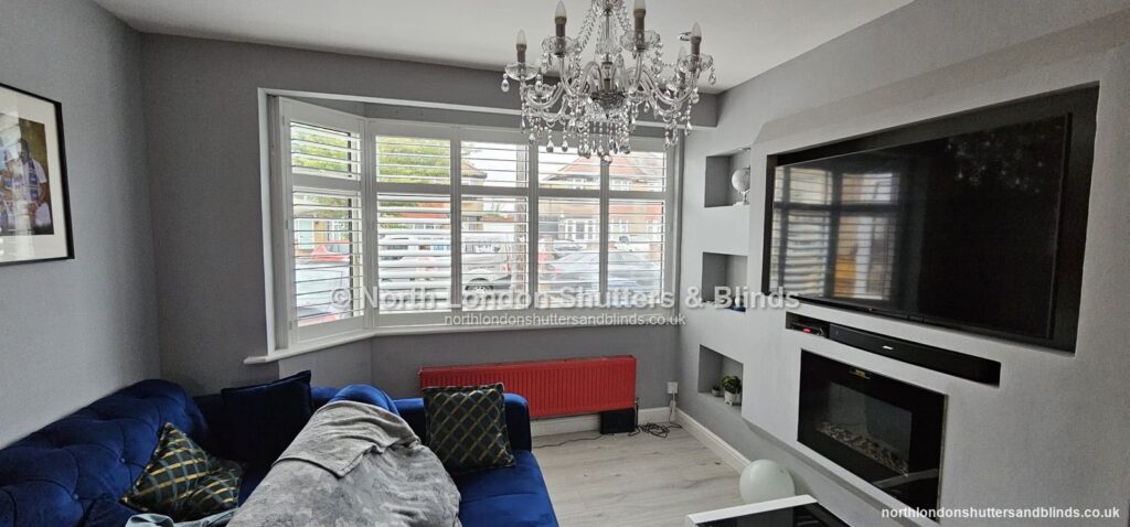 White full height plantation shutters on a bay window in a living room by shutter fitters in Barnet, North London