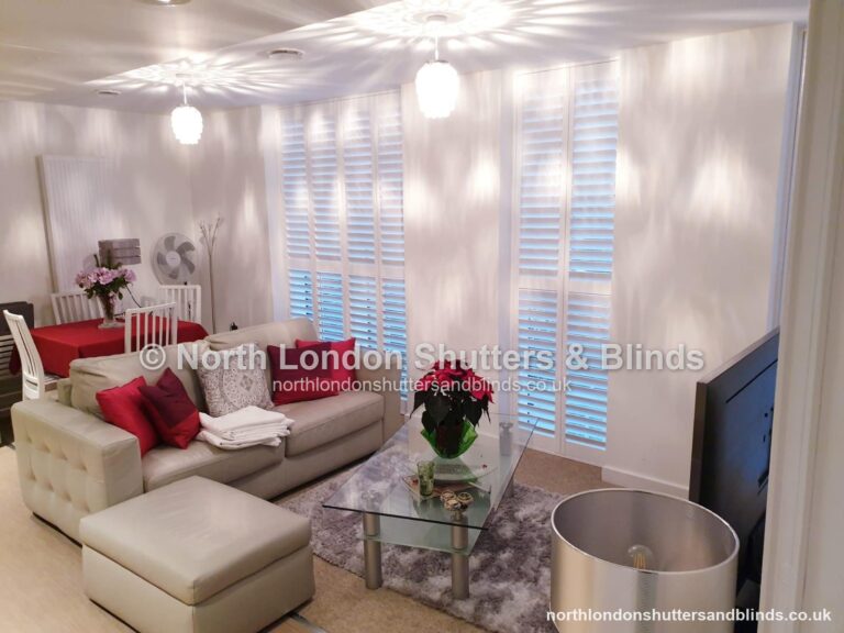 White full height plantation shutters on floor-to-ceiling windows in a living room by shutter fitters in Barnet, North London