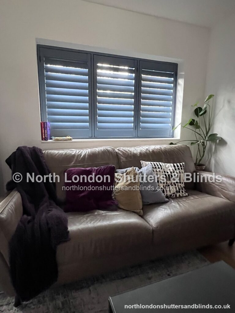 Grey full height plantation shutters in a living room, with the louvres closed by shutter fitters in Barnet, North London
