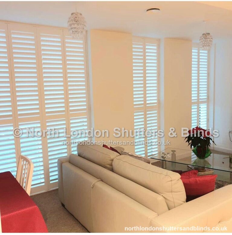 White full height plantation shutters on a tall window in a living room by shutter fitters in Barnet, North London