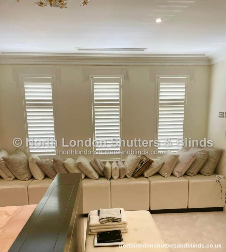 White full height plantation shutters on three windows in a living room by shutter fitters in Barnet, North London
