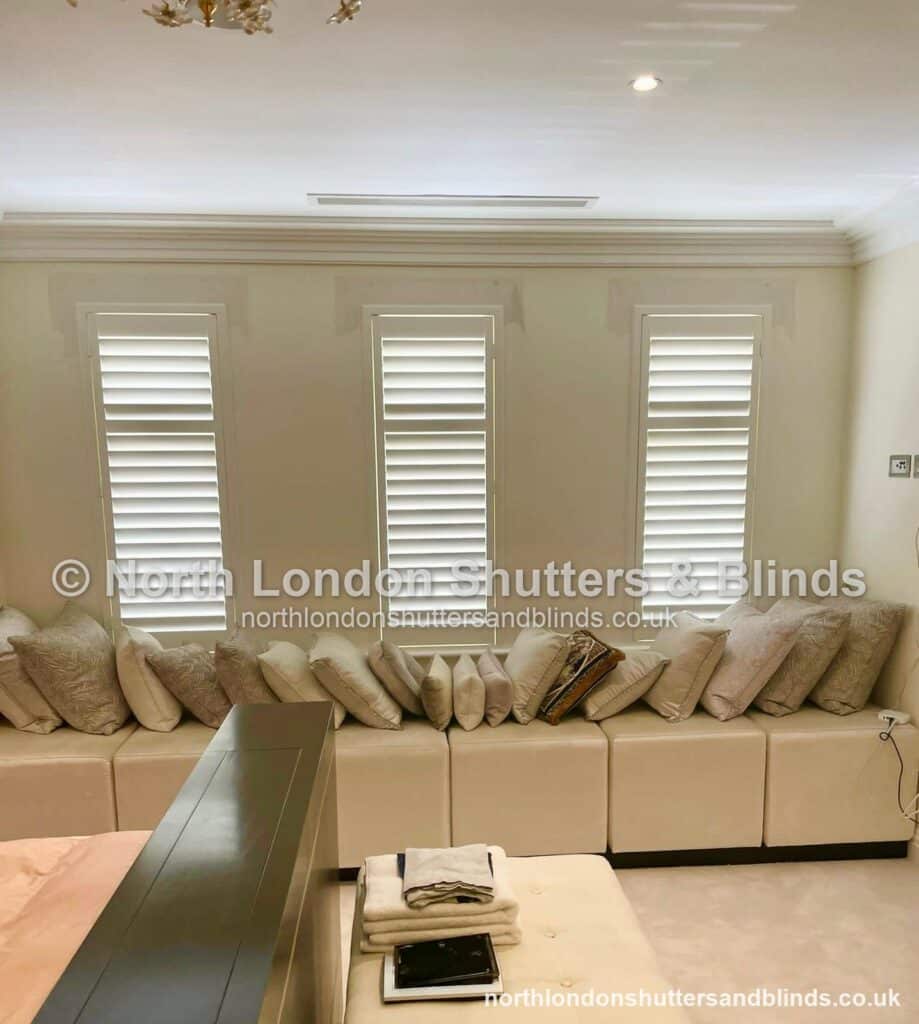 White full height plantation shutters on three windows in a living room by shutter fitters in Barnet, North London