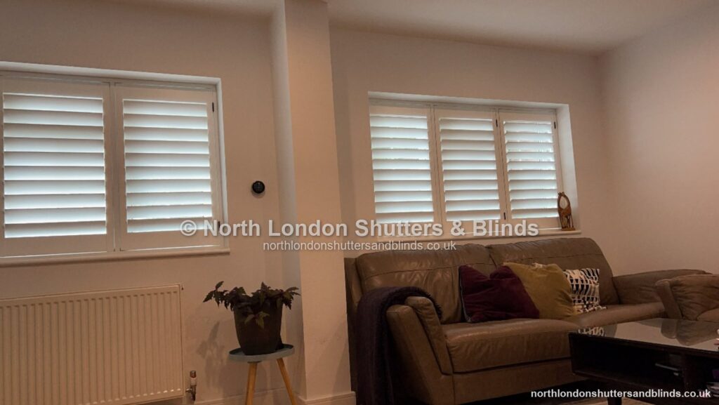 White full height plantation shutters on two windows in a living room by shutter fitters in Barnet, North London