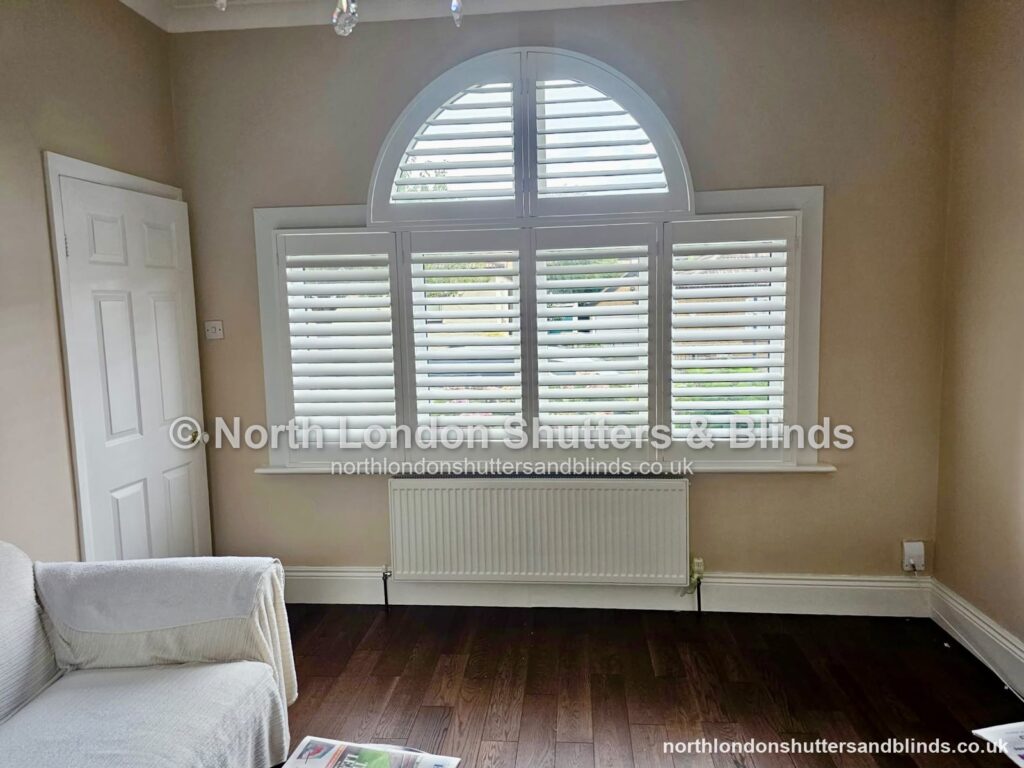 White special shape plantation shutters on an arched fan window in a living room by shutter fitters in Barnet, North London