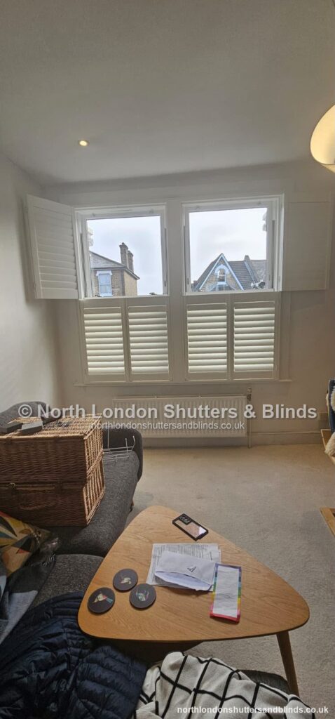 White tier-on-tier plantation shutters in a living room by shutter fitters in Barnet, North London