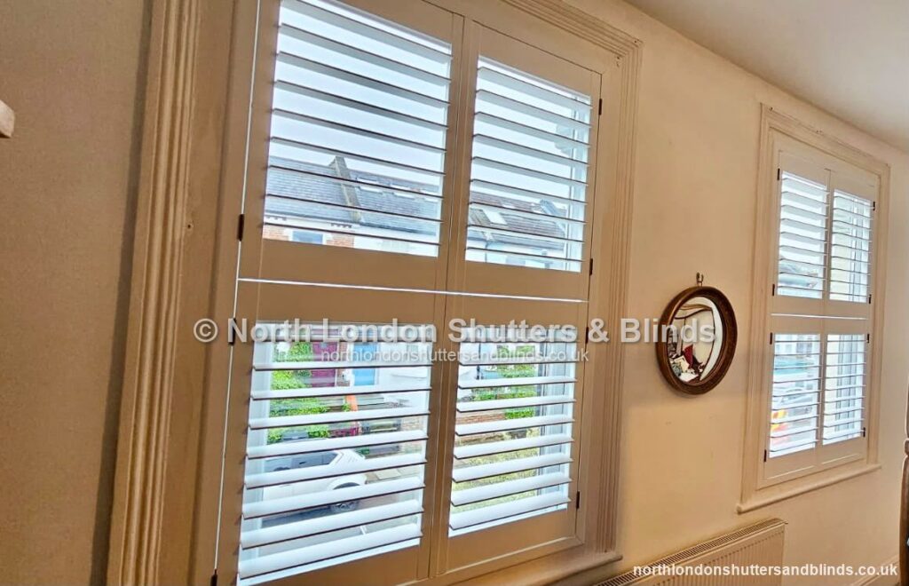 White tier-on-tier plantation shutters in a living room by shutter fitters in Barnet, North London