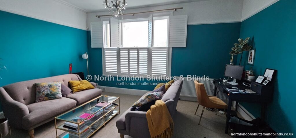 White tier-on-tier plantation shutters in a living room, with the top panels folded open by shutter fitters in Barnet, North London