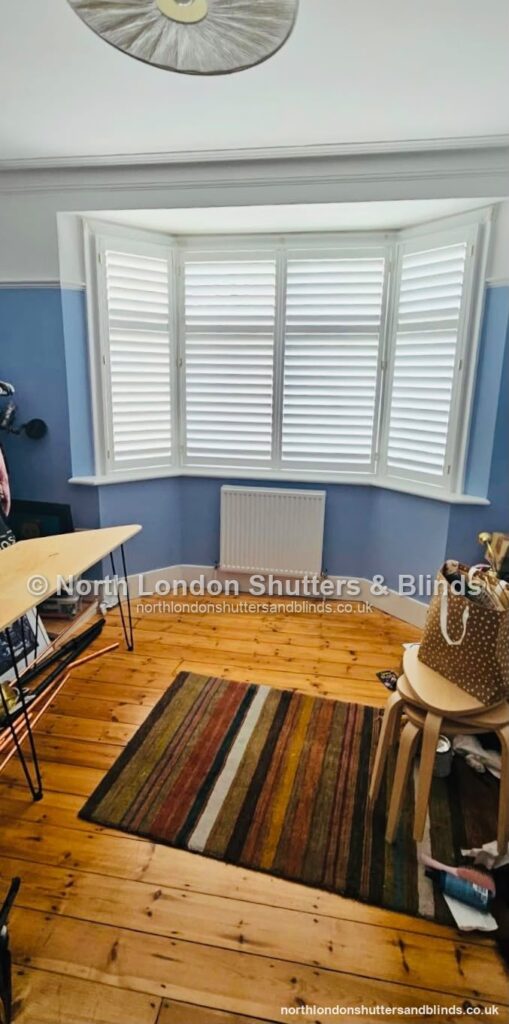 White full height plantation shutters on a bay window in a study by shutter fitters in Barnet, North London