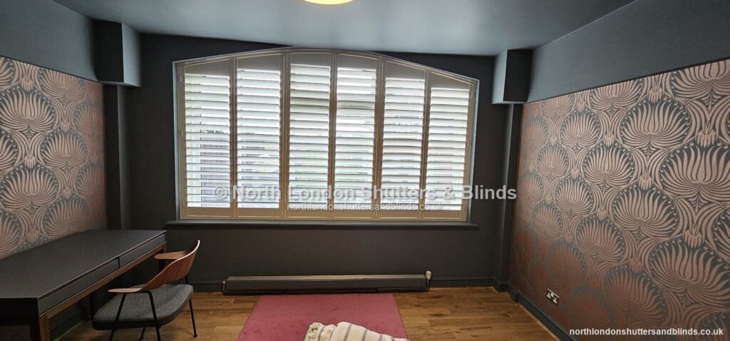 White special shape plantation shutters on an arched window in a study by shutter fitters in Barnet, North London