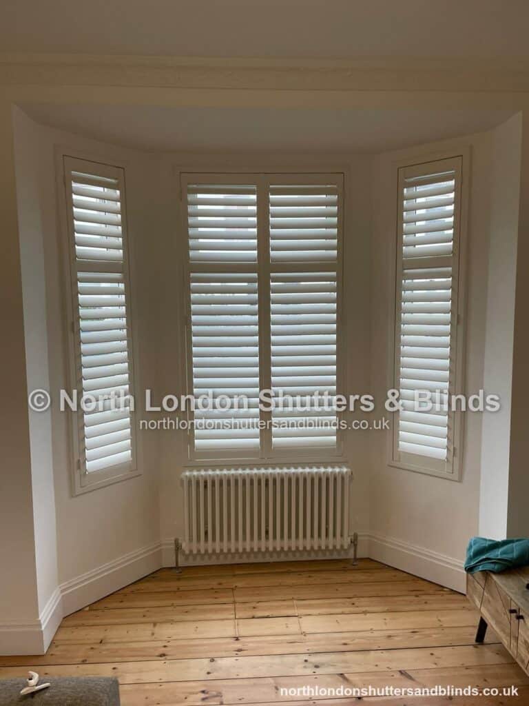 White tier-on-tier plantation shutters on a bay window by shutter fitters in Barnet, North London
