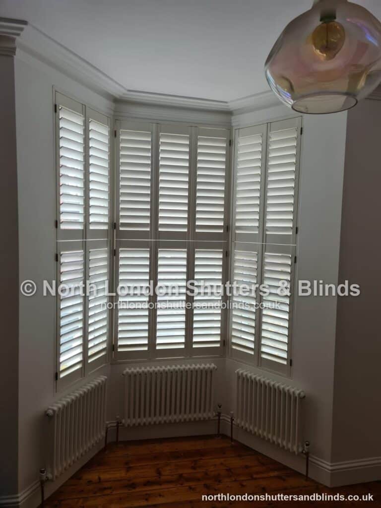 White tier-on-tier plantation shutters on a bay window by shutter fitters in Barnet, North London