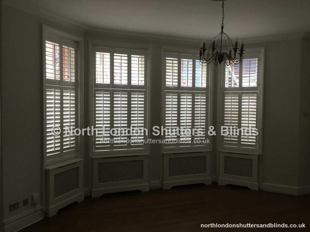 White tier-on-tier plantation shutters on a curved bay window by shutter fitters in Barnet, North London