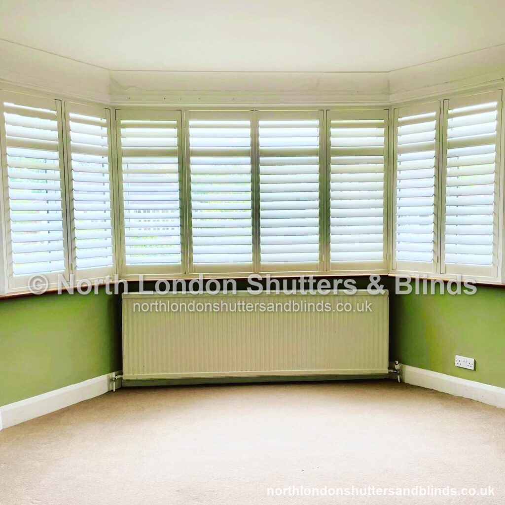 White tier-on-tier plantation shutters on a large bay window by shutter fitters in Barnet, North London